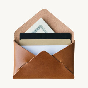 Brown leather envelope wallet with cards and a dollar bill inside. The wallet is open, showcasing its contents.