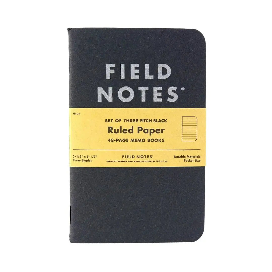 Black Field Notes notebook with yellow band and ruled paper details.