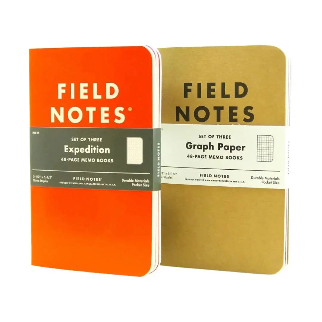 Two Field Notes notebooks, one orange and one gold with graph paper.