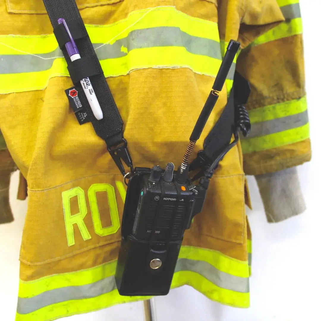 Firefighter radio strap with Motorola radio and pens attached to yellow bunker gear.