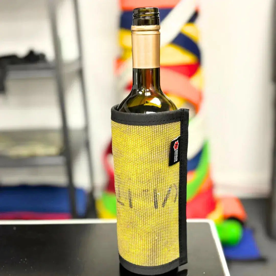 Yellow firehose wine bottle cover with black trim on a table.