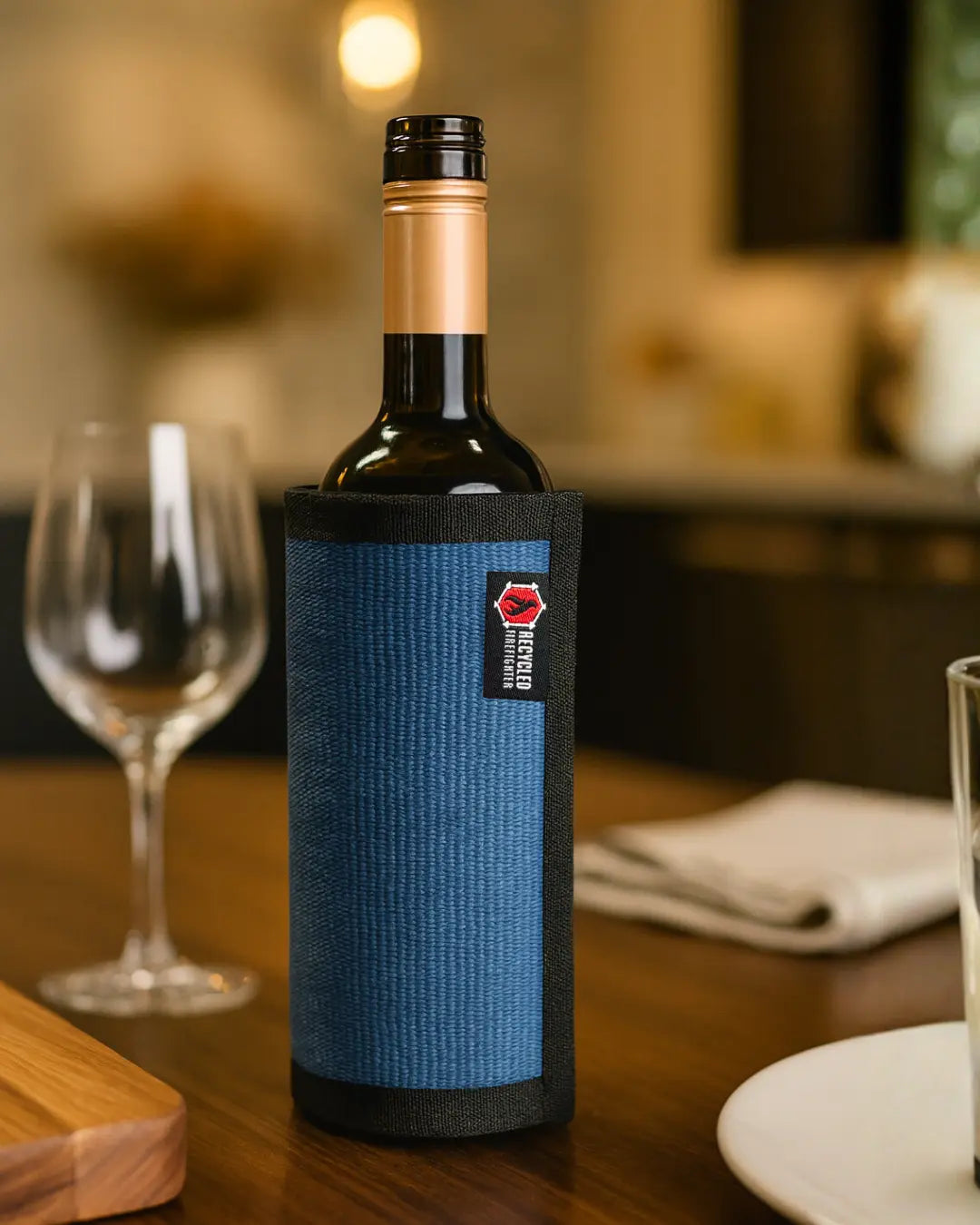 Blue firehose wine bottle cover with recycled firefighter gear label.