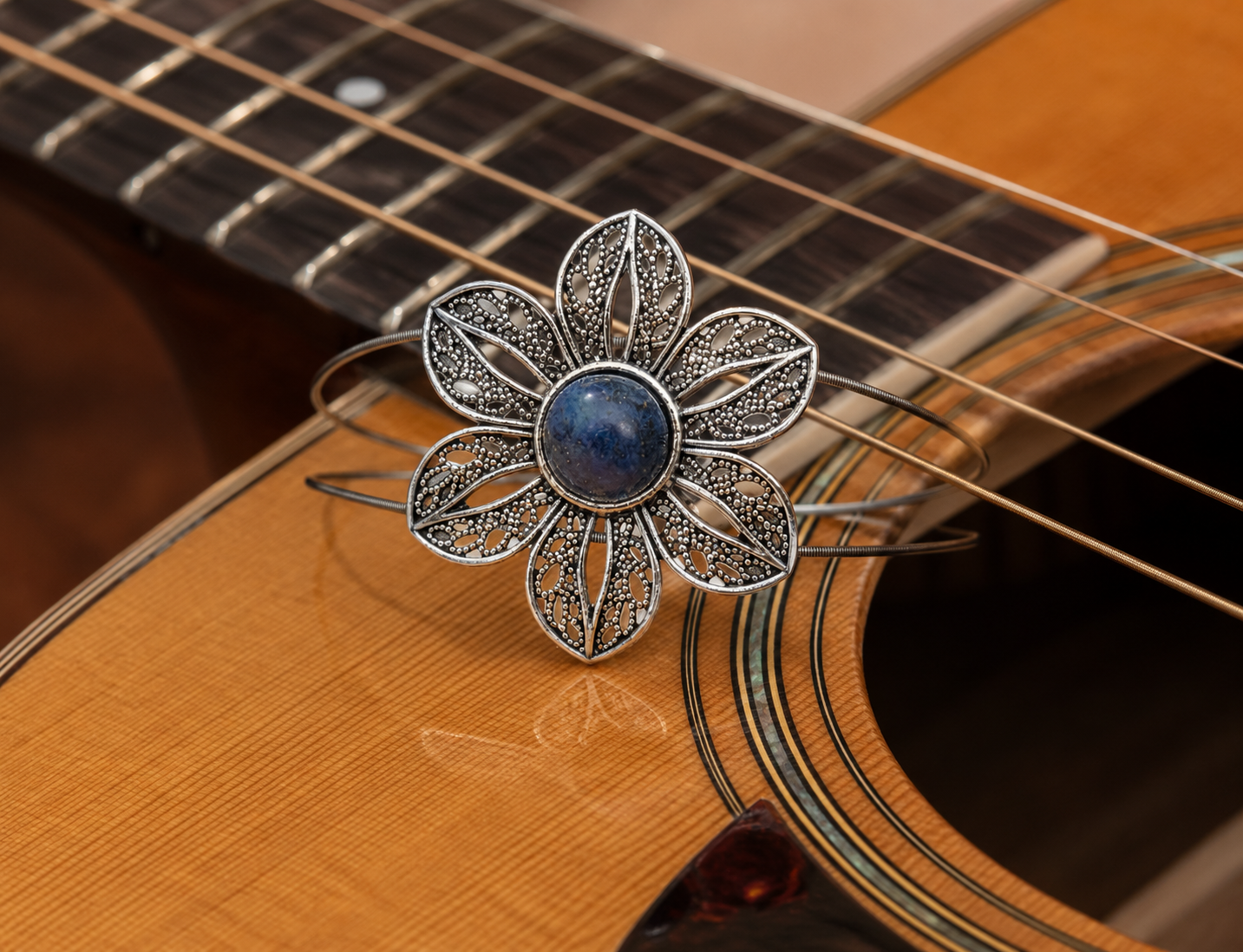 Lapis flower bracelet displayed on acoustic guitar