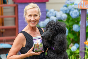 Woman holding Ginger Quince Goats Milk Arnica Bath Salts with a poodle dog.