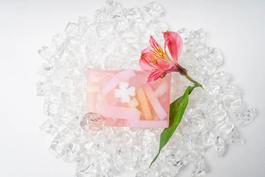 Pink Grapefruit Splash soap slice with flower and ice on a white background.