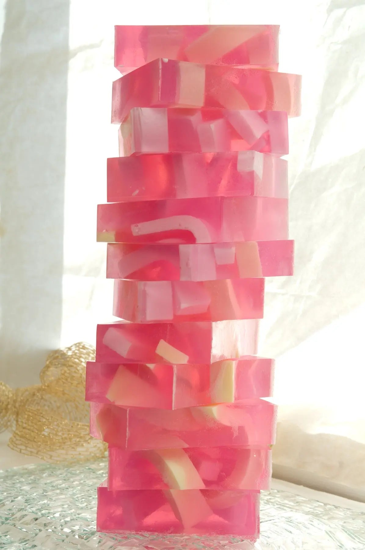 Pink grapefruit splash soap slices stacked in a tower with white and yellow pieces inside.