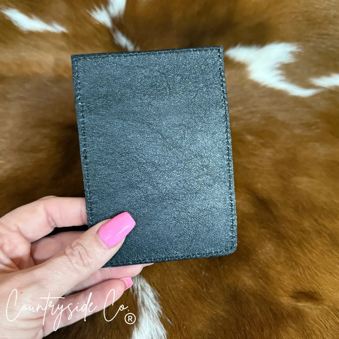 Black tooled leather credit card holder with hand holding it.