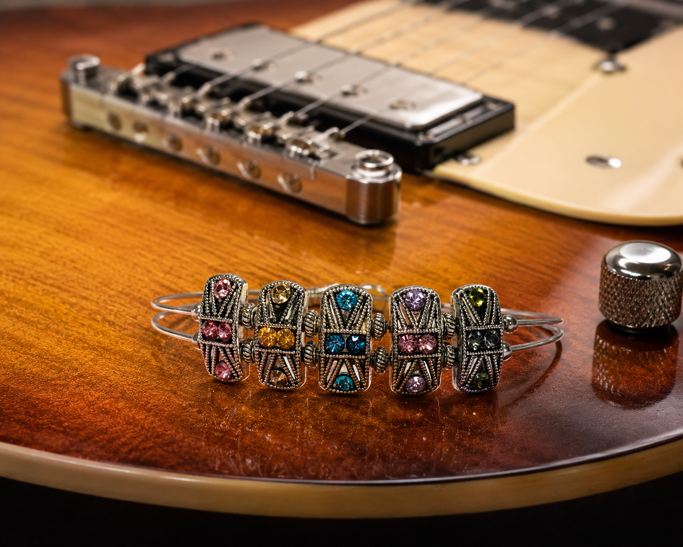 Rainbow rhinestone guitar string bracelet on guitar