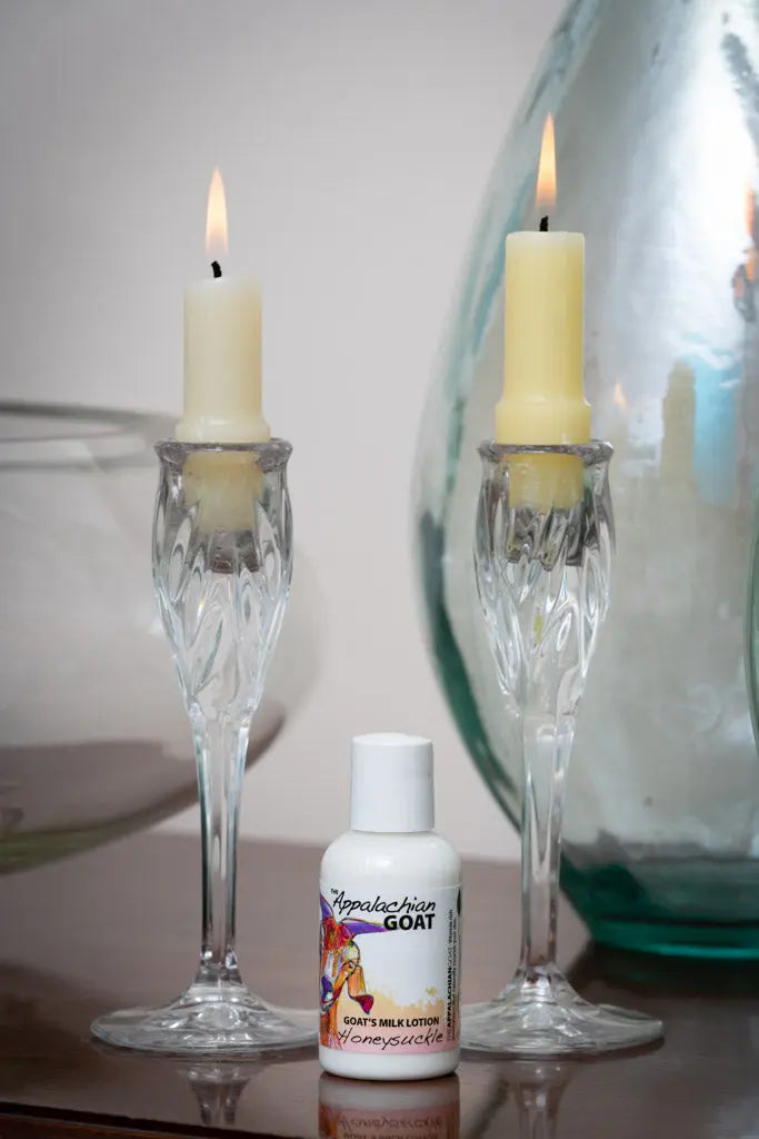 Honeysuckle Goat Milk Lotion with candleholders and glass vase.