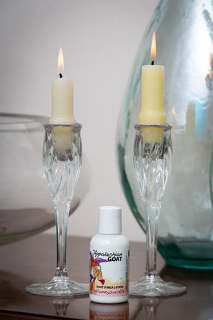 Honeysuckle Goat Milk Lotion with candleholders and glass vase.