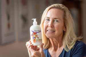 The Appalachian Goat Honeysuckle Goat's Milk Lotion bottle held by a woman