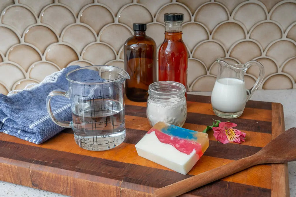 Colorful HONEYSUCKLE GOATS MILK SOAP SLICE 5 oz. with ingredients and soap-making tools.