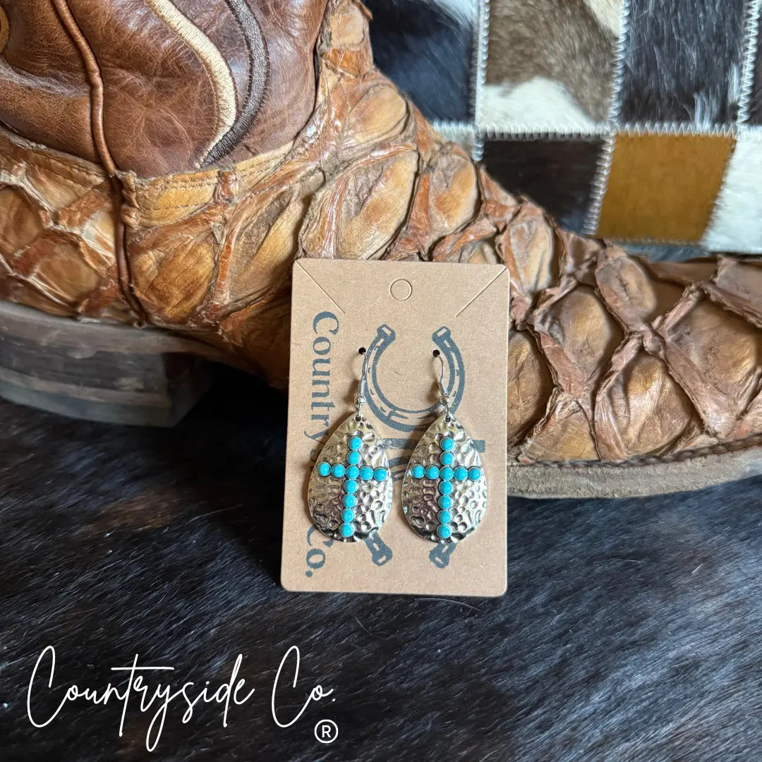 Hammered silver cross dangle earrings with turquoise stones.