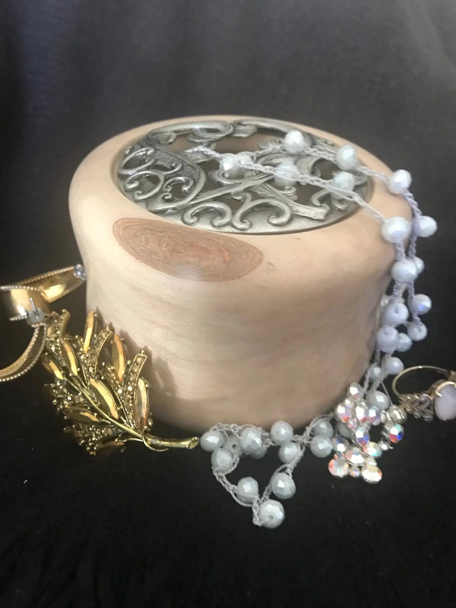 River birch treasure box with metal lid and jewelry, including pearl necklace, rings, and gold leaf brooch.
