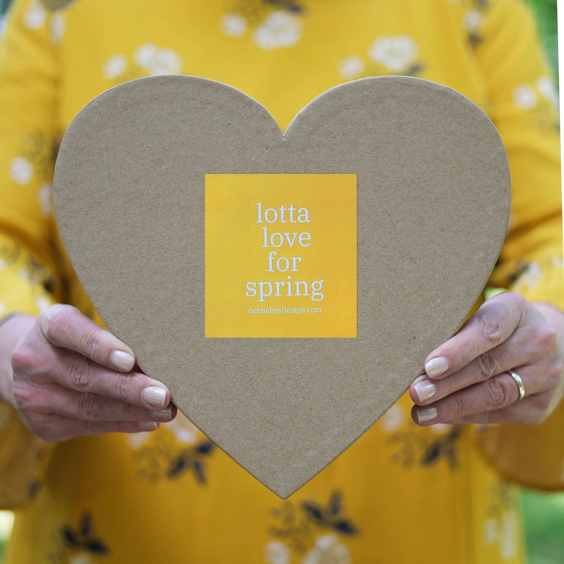 Heart-shaped box with a yellow sticker featuring white text.