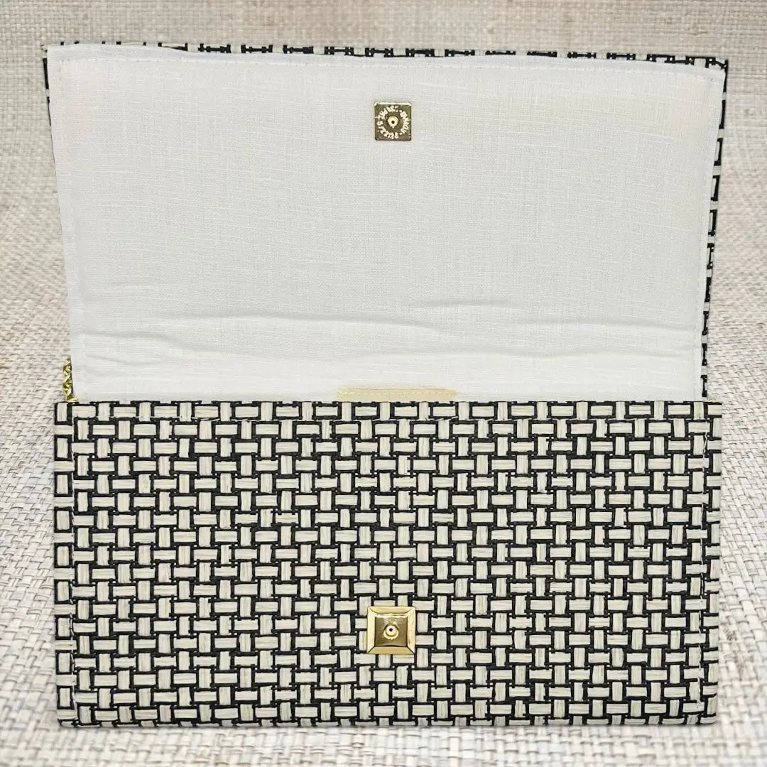 Jana Crossbody Clutch with woven black and white grasscloth and gold snap closure.