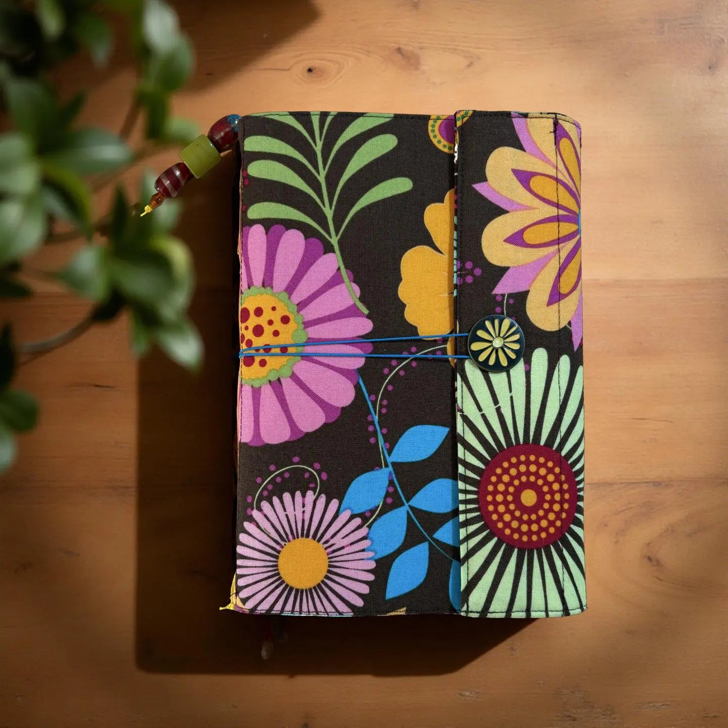 Hand sewn journal with floral pattern cover, button closure, and attached beaded bookmark.