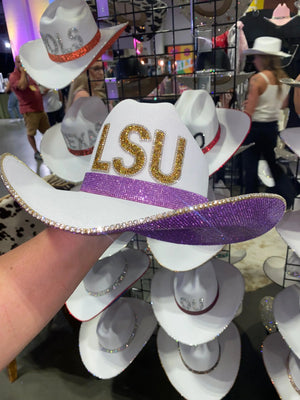 White cowgirl hat with gold LSU letters and purple rhinestone band.