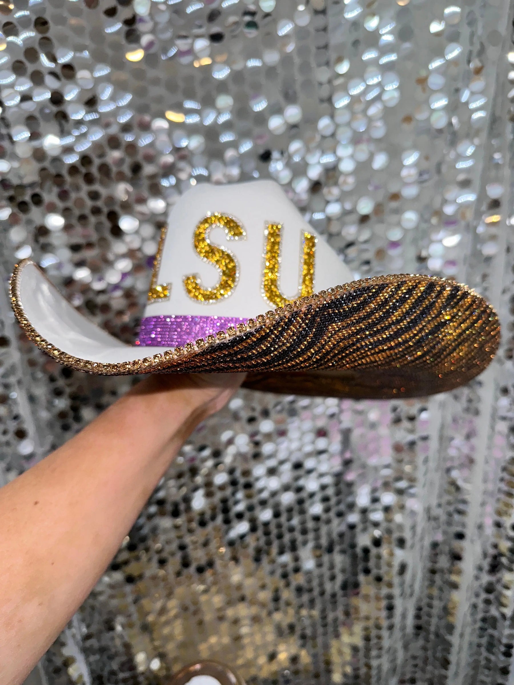 White cowboy hat with gold LSU letters and tiger print rhinestones.