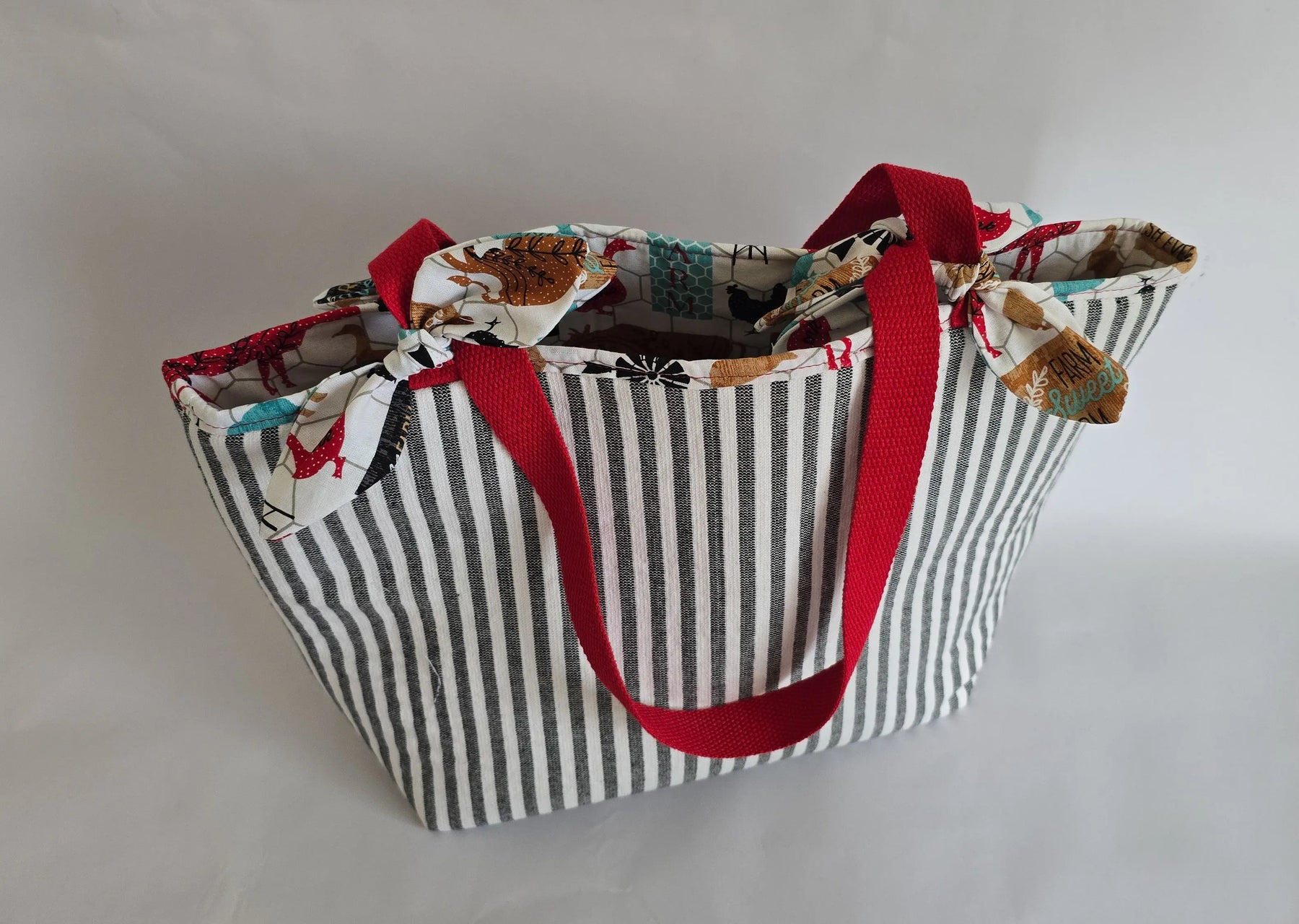 Handmade canvas tote bag with black and white stripes, red straps, and a chicken-themed lining and ties.
