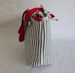 Black and white striped canvas tote bag with red shoulder straps. Reusable shoulder bag.