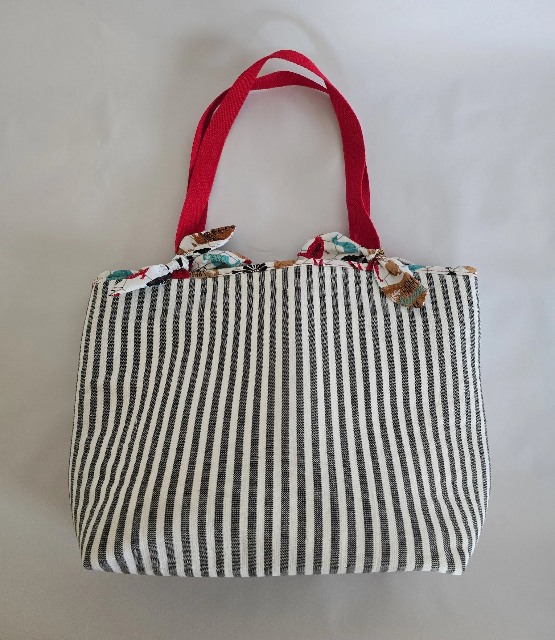 Striped canvas tote bag with red straps, a handmade shoulder bag.