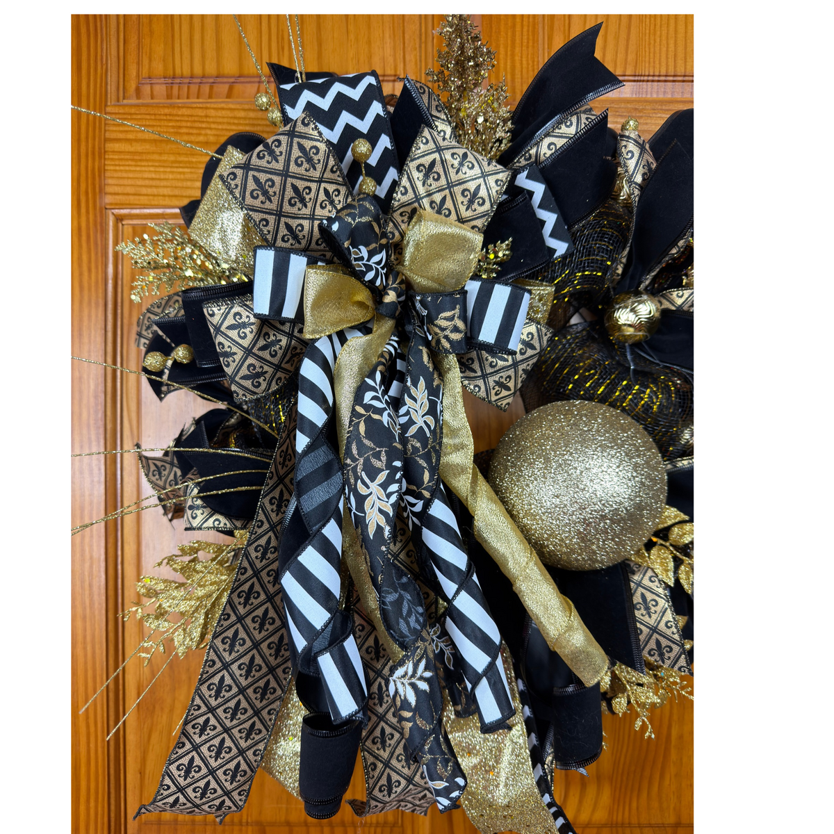 Black and gold fleur-de-lis wreath by Bouge Creations with designer ribbon, decorative mesh and a gold ornament