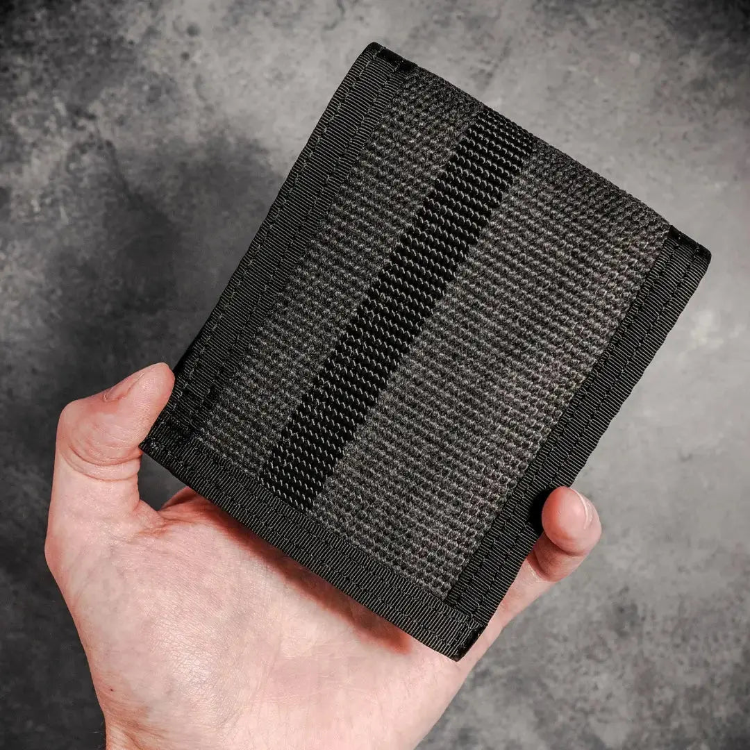 Black fire hose bifold wallet held in hand