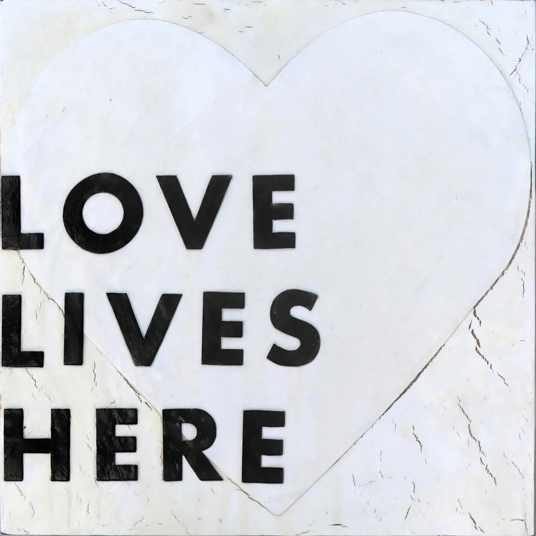 Love Lives Here art print with black text on a white heart.