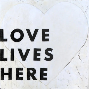 Love Lives Here art print with black text on a white heart.
