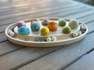 Maple sorting tray holding colorful wooden toy pieces.