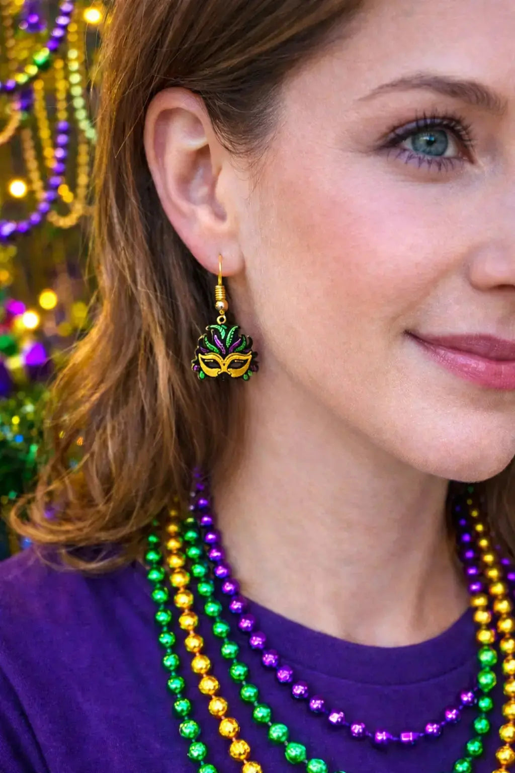 Mardi Gras mask earrings: purple, green, and gold on woman with beaded necklaces. Handmade jewelry from Main Street Collective.