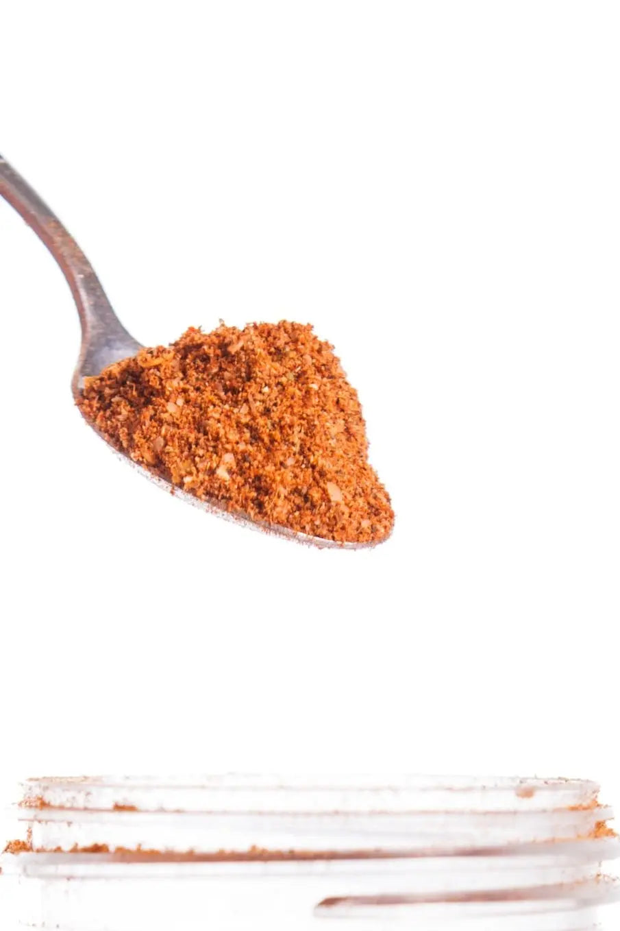 Pouring Mexican Adobo Seasoning: Spoonful of MEXICAN ALL PURPOSE spice by Main Street Collective for authentic flavor.