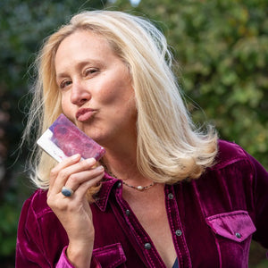 Woman holding Pomegranate Goat's Milk Soap slice, 5 oz, Main Street Collective.