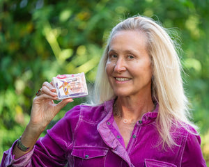 Woman holding pomegranate goat milk soap bar