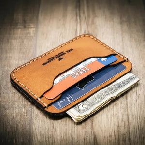 Brown leather card wallet holding credit cards and US dollar bills.