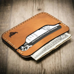 Brown leather card wallet with embossed bull logo, holding a card and cash.