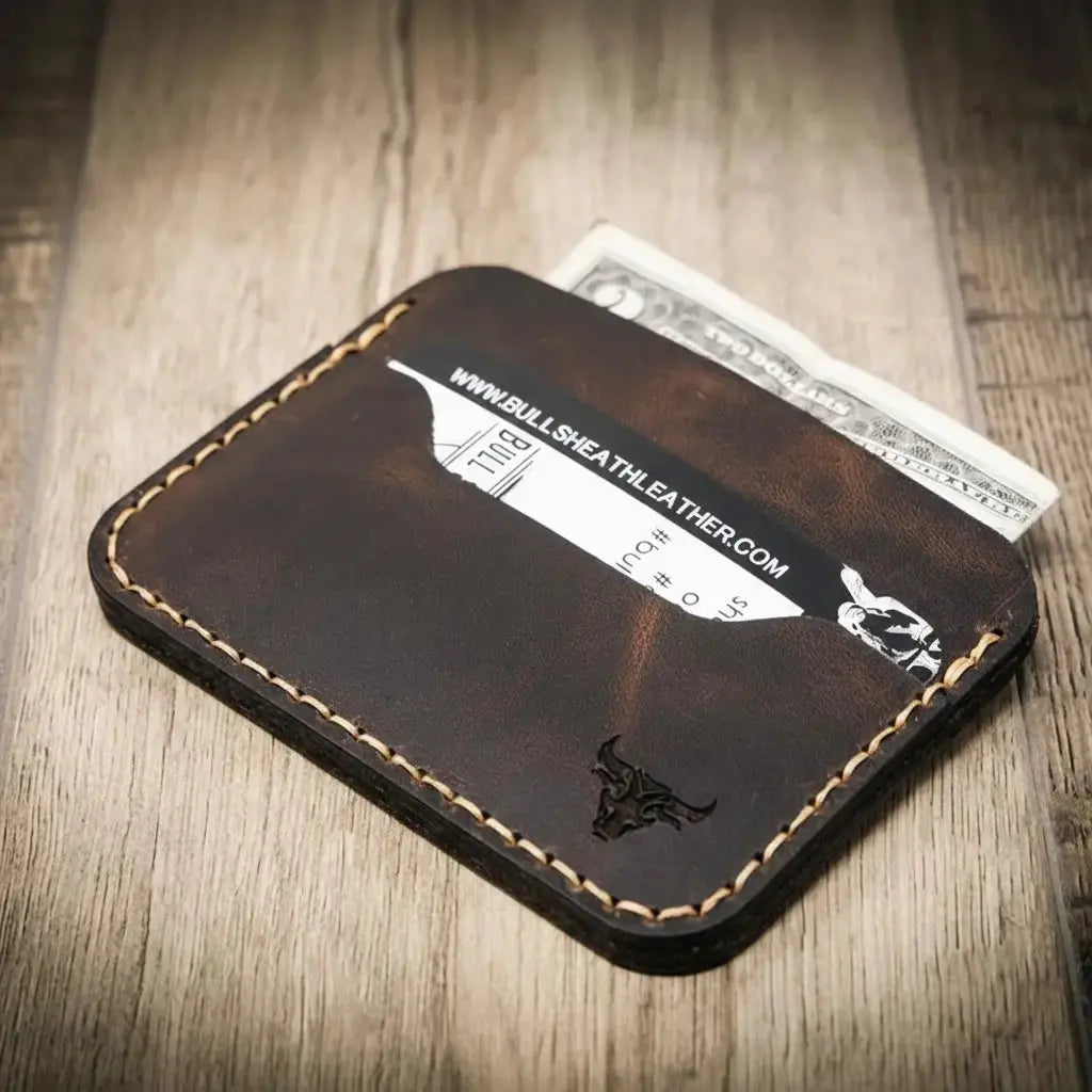 Brown leather cardholder with credit card and cash.