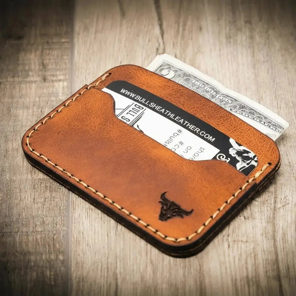 Brown full grain leather card wallet with visible stitching, card, and cash.