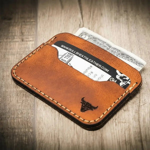Brown full grain leather card wallet with visible stitching, card, and cash.
