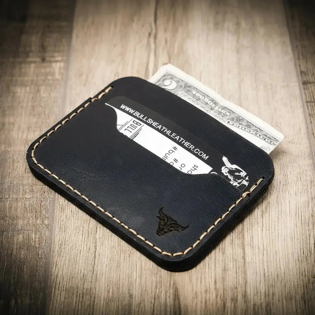Black leather minimalist card wallet with stitched edges and a bull logo.