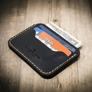 Black leather minimalist wallet holding Texas ID and cash