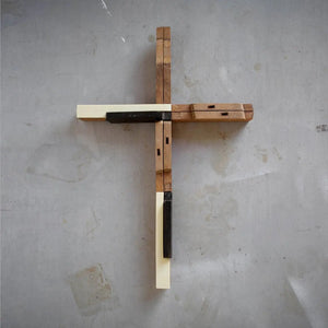 Wooden cross made from reclaimed antique piano keys in white, black, and natural wood.