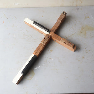 Wooden cross crafted from antique piano keys, showing visible wood grain and key details.