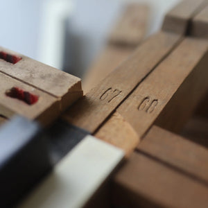 Close-up of reclaimed antique piano keys marked '67' and '68'.