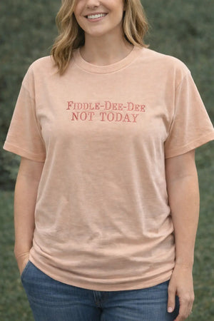 Woman wearing a peach t-shirt with the embroidered text "Fiddle-Dee-Dee Not Today"
