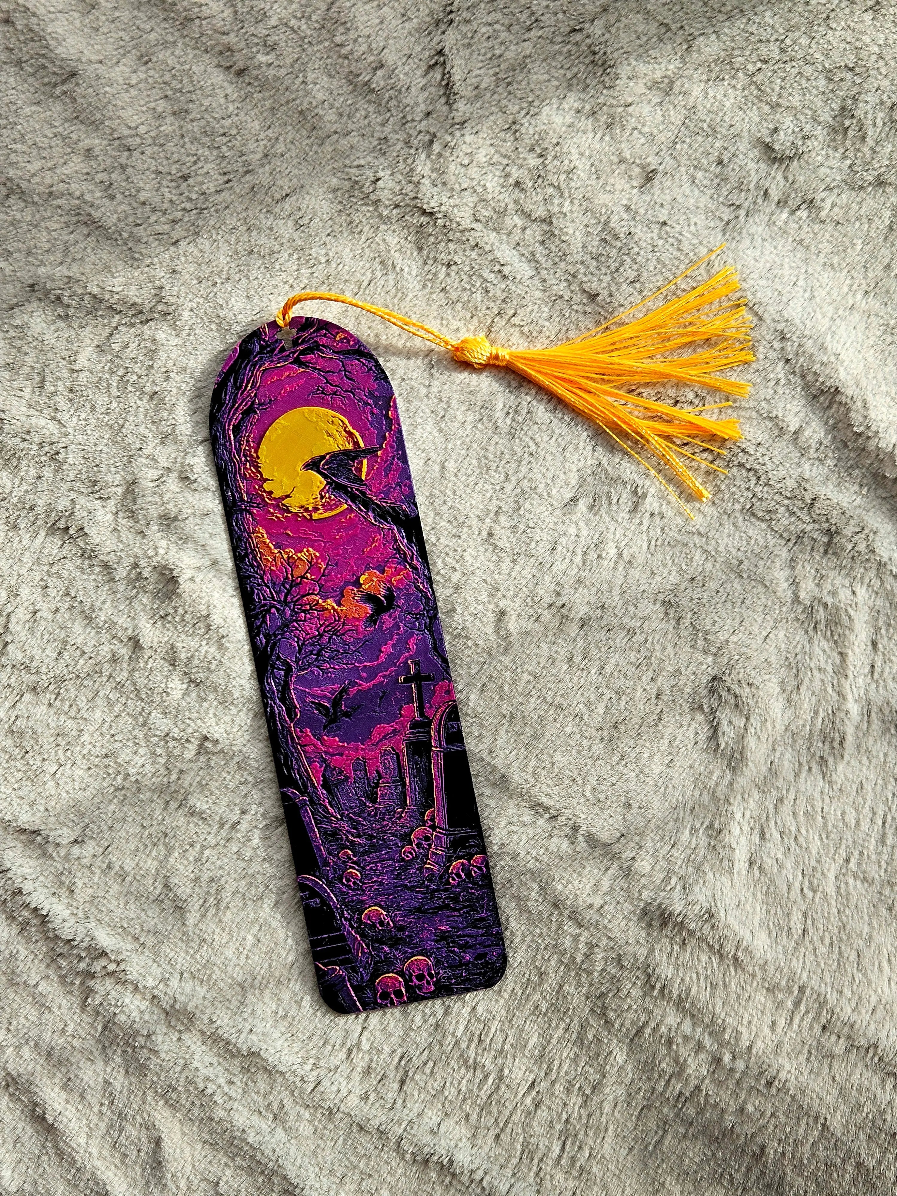 Gothic bookmark with a raven, moon, and cemetery scene with a yellow tassel.