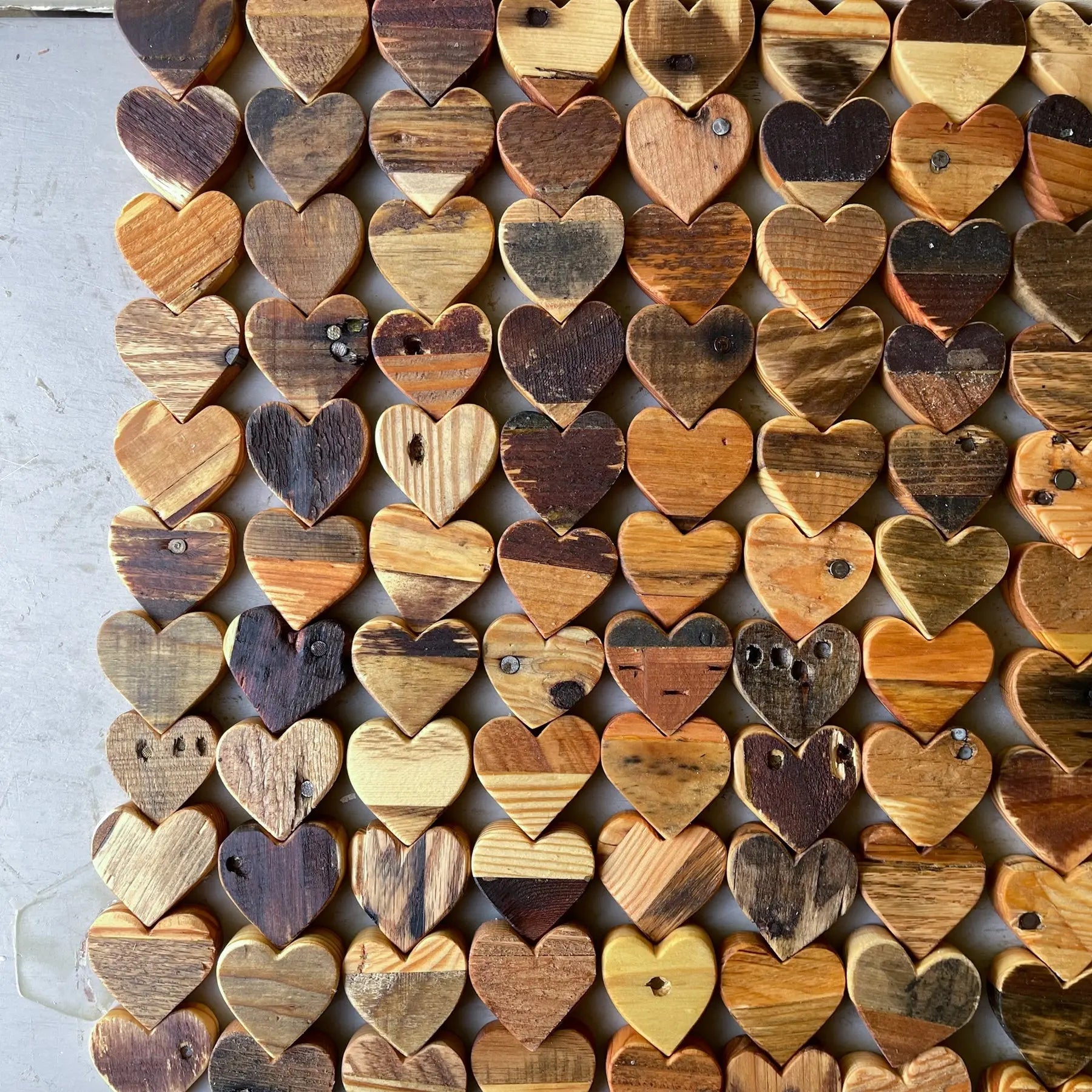 Collection of reclaimed pallet wood hearts with natural wood grain and variations.
