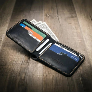 Black leather bifold wallet with cards and cash on wooden background