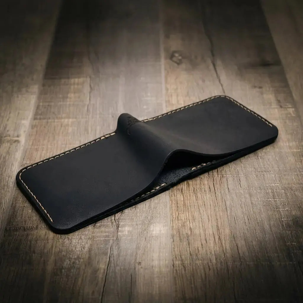 Black leather bifold wallet on a wooden surface.